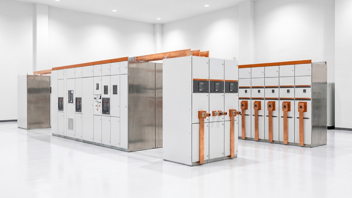 A modern medium-voltage electrical switchgear room with rows of switchgear cabinets