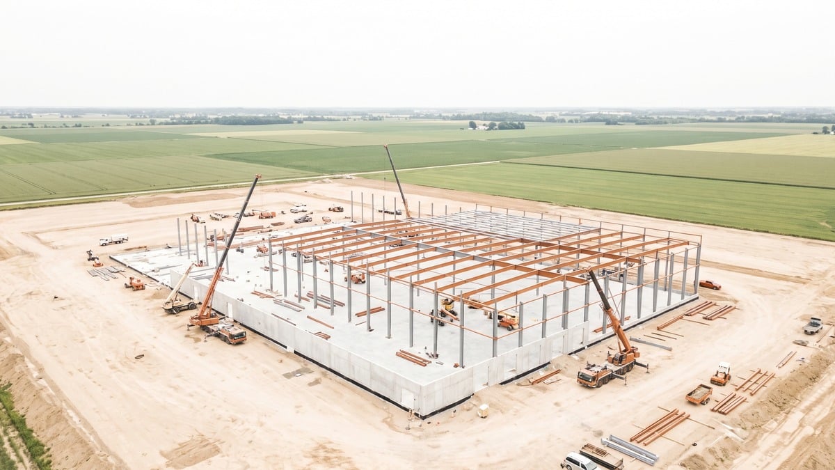 Aerial photograph of a large industrial building under construction on cleared land